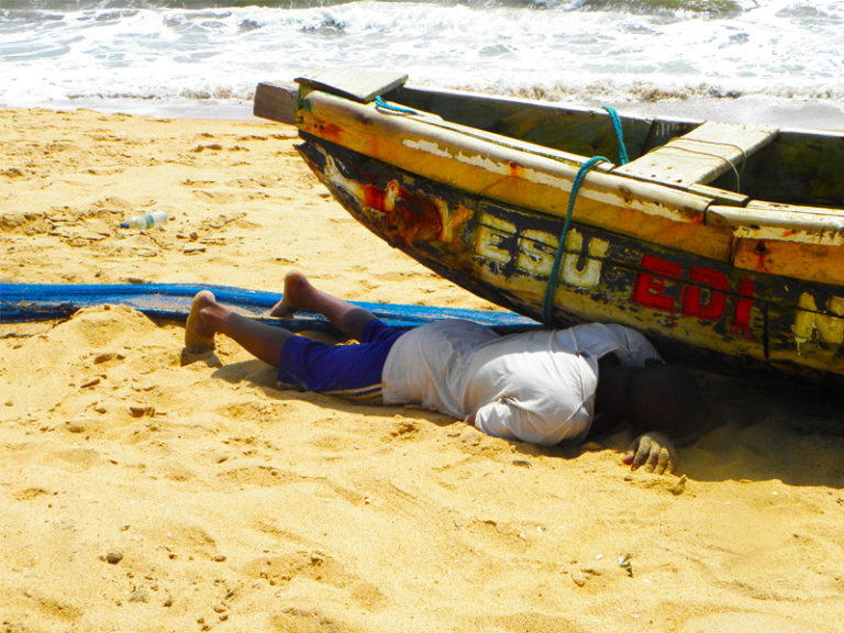 homme sommeillant sous la pirogue - grand popo - bénin