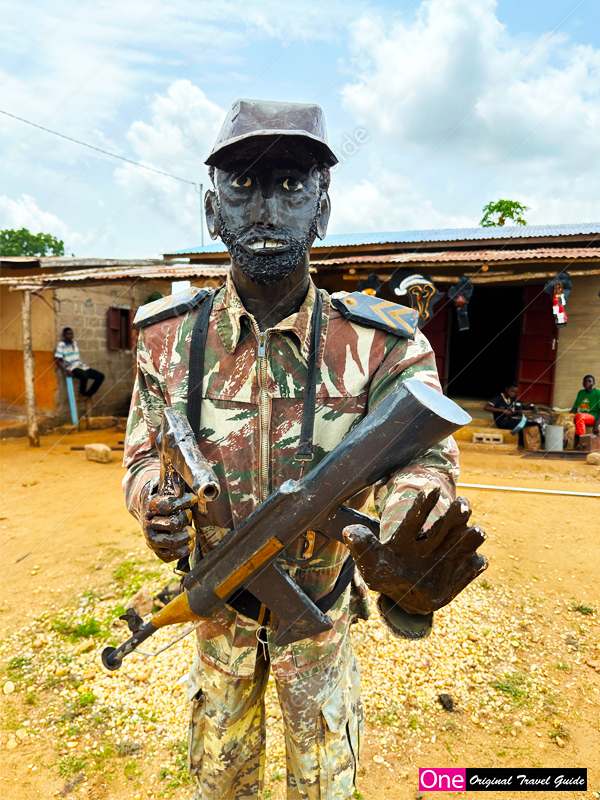 Statue d’un “policier en arme menaçant” – Comé – Bénin Statue d'un "policier en arme menaçant" Comé - Bénin